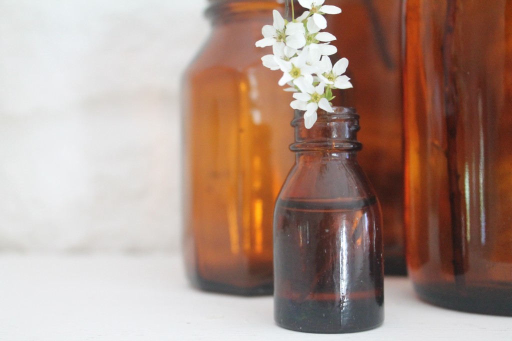 vintage amber bottles with spring blooms against stone