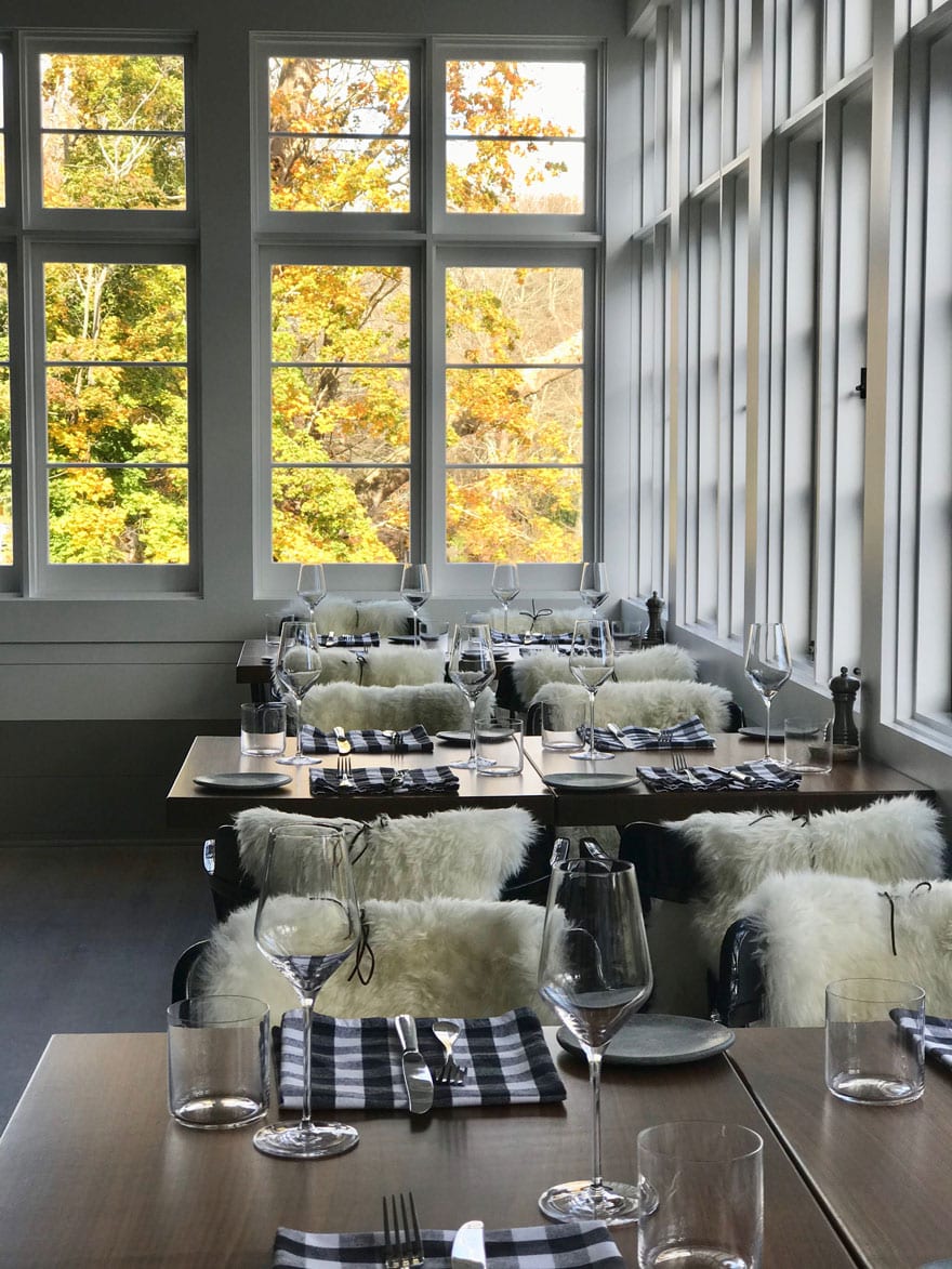 The dining room at GrayBarns Tavern overlooking the Silvermine River. Each chair has a sheepskin tied with a piece of leather to hold it in place.