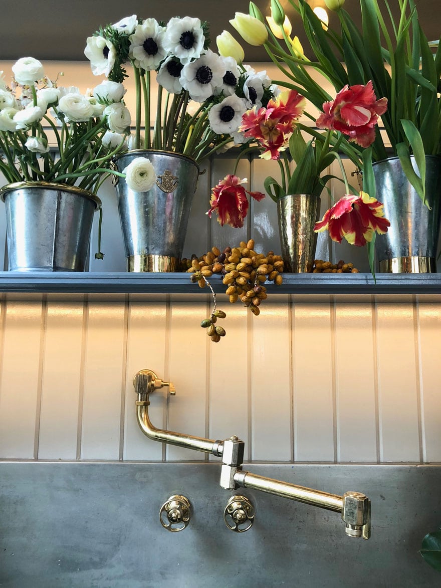 flowers in sink with brass faucet