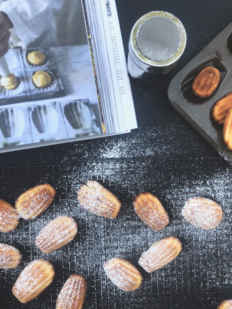 madeleines on black with confectioners sugar