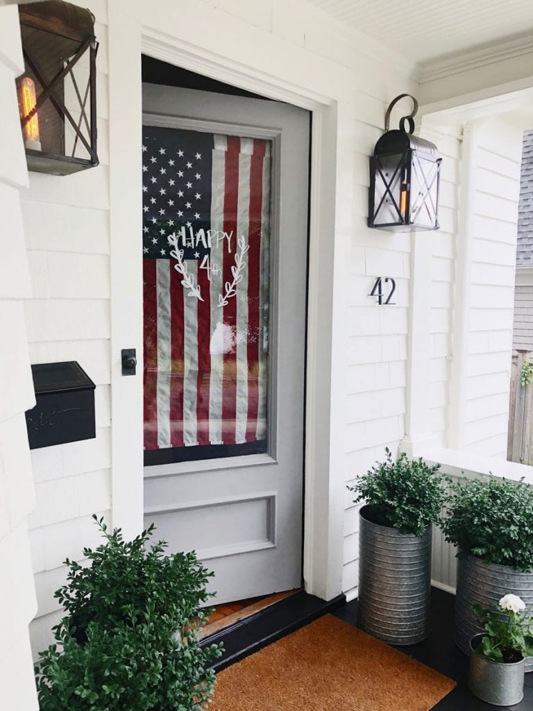 white house with usa flag on glass door, planters