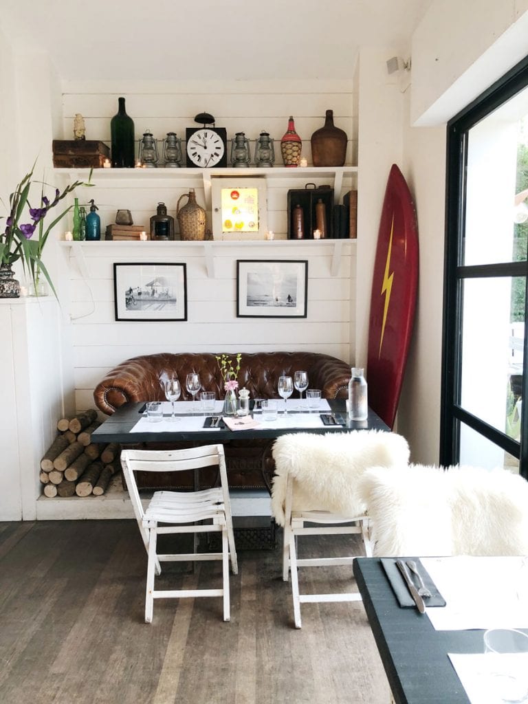 table, sofa, chairs, surf board, bottles