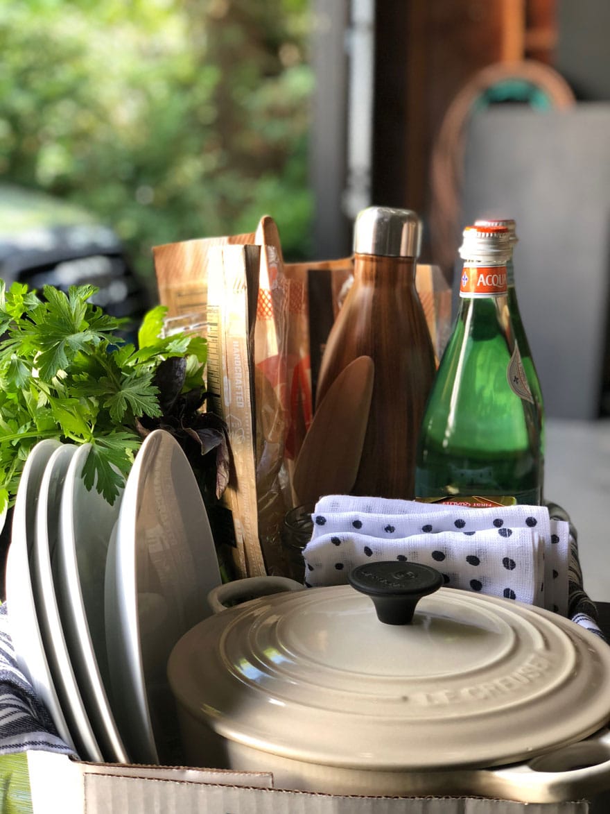 plates, dutch oven, fresh herbs, water bottles, bread in box