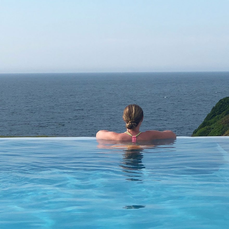 girl in pool overlooking ocean
