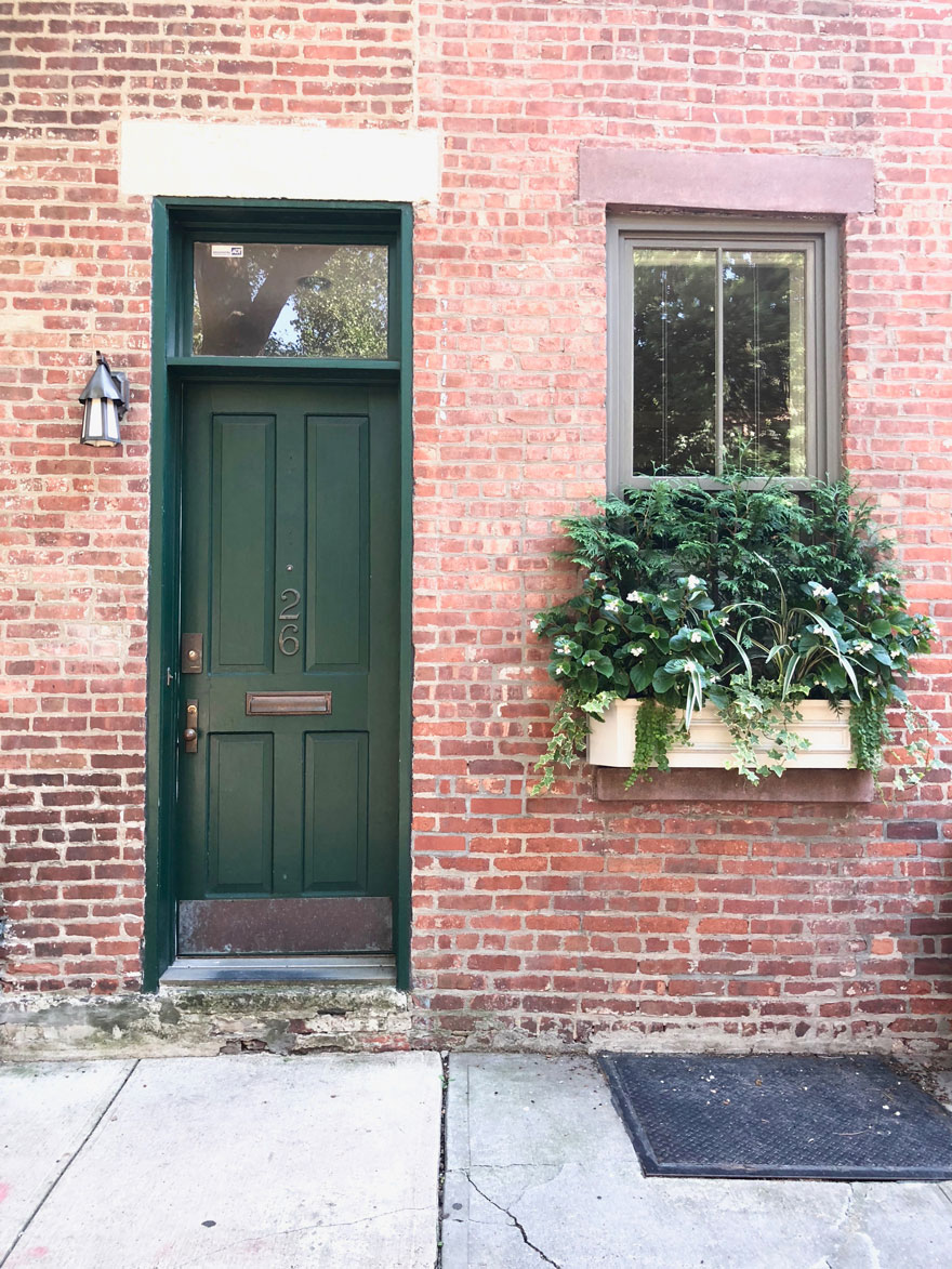 green door, window box on brick house