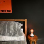 bed, black walls, small light