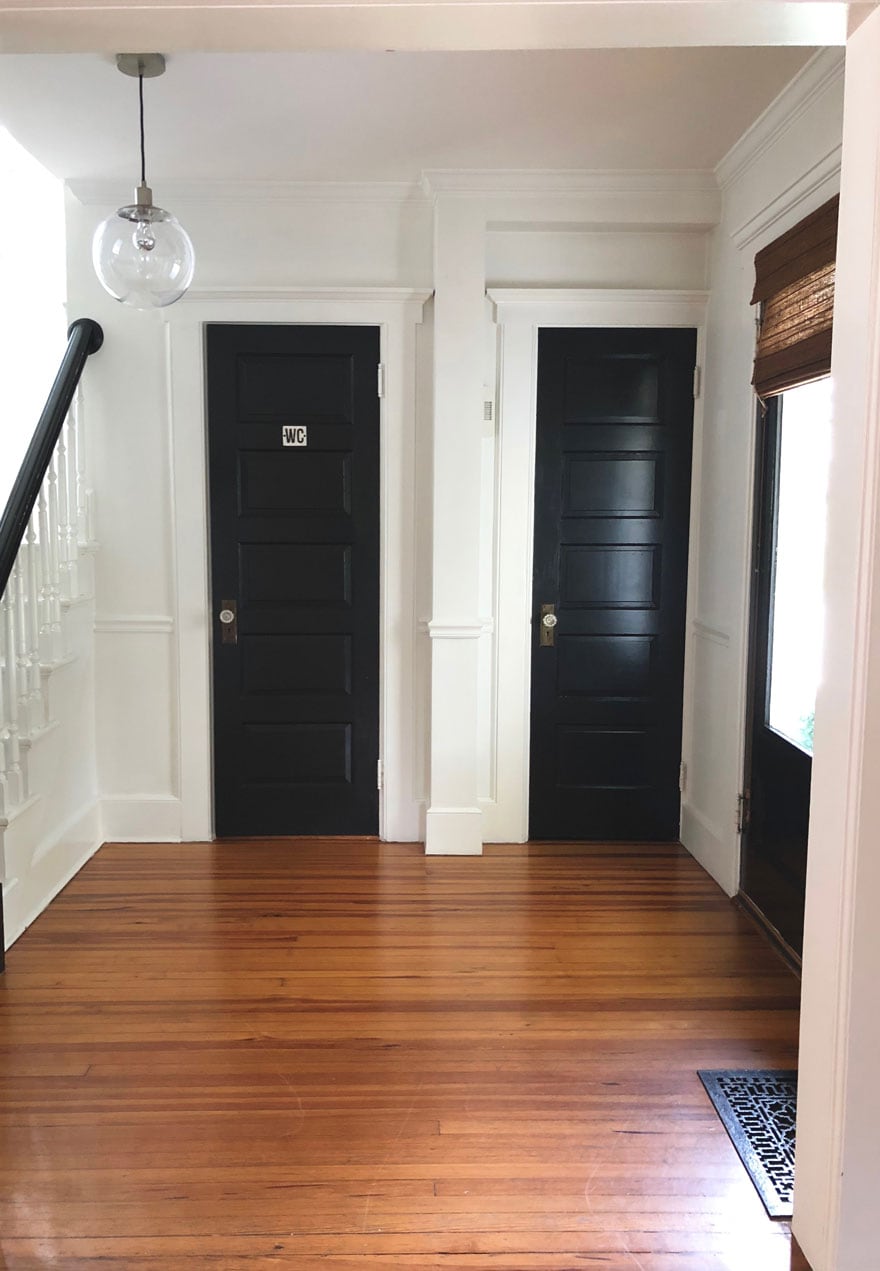 black doors in foyer with wood floors