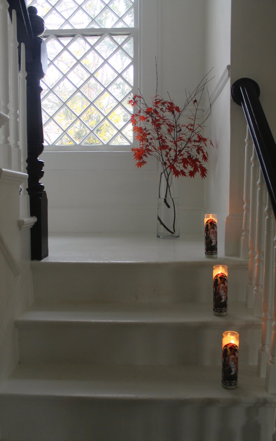 white painted stairs, red leaves in vase, religious candles