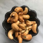 small pewter bowl with cashews on marble counter