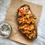 vegetable on toast with small jar of salt on paper