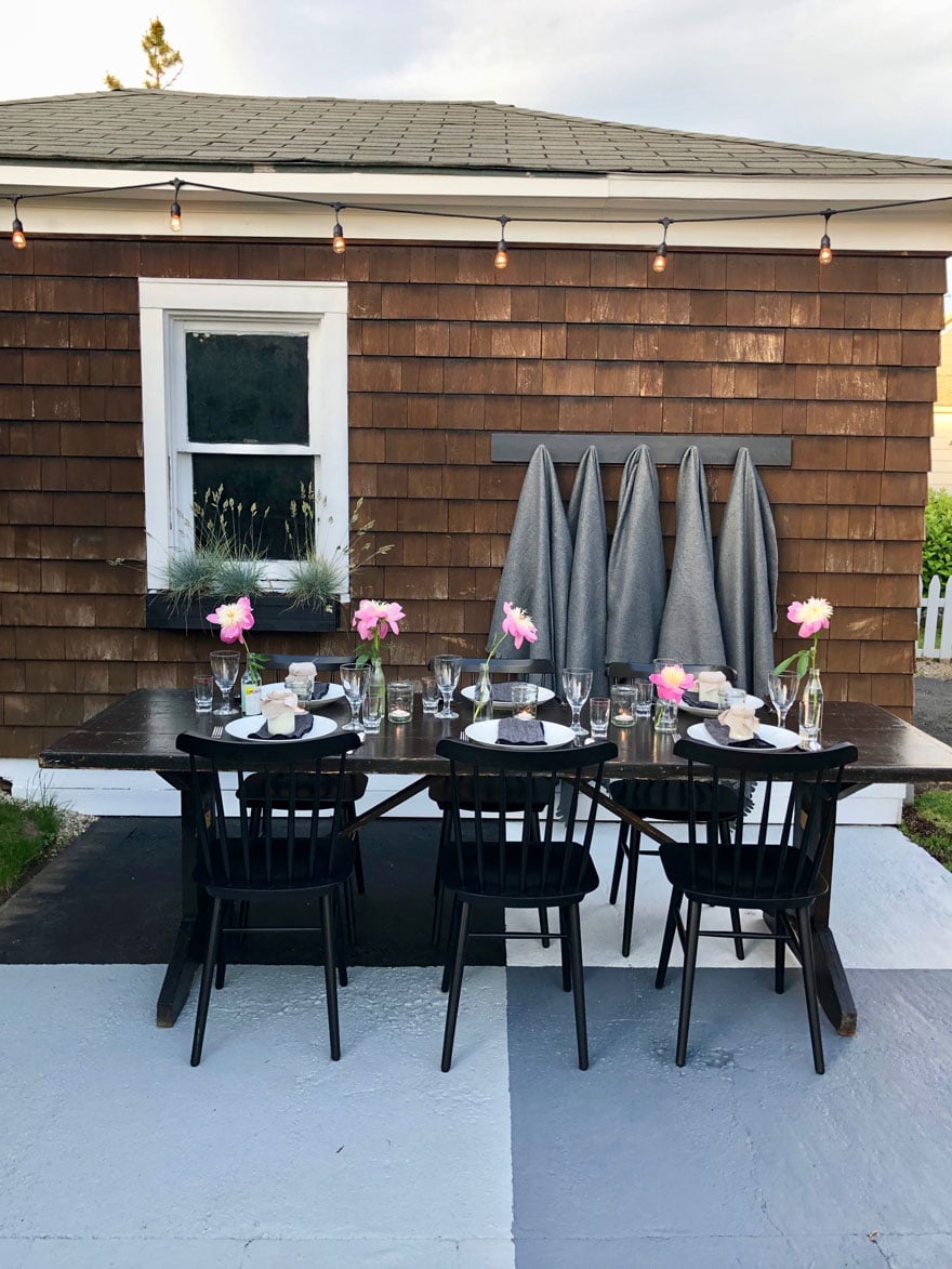 table on patio seat with pink flowers, window on side of garage
