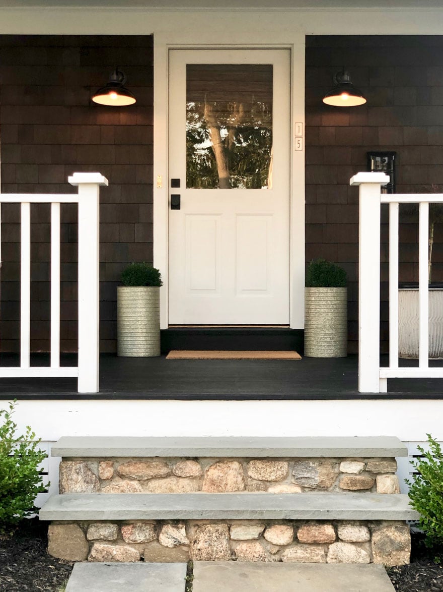 front door with glass, planters, lights, stone steps