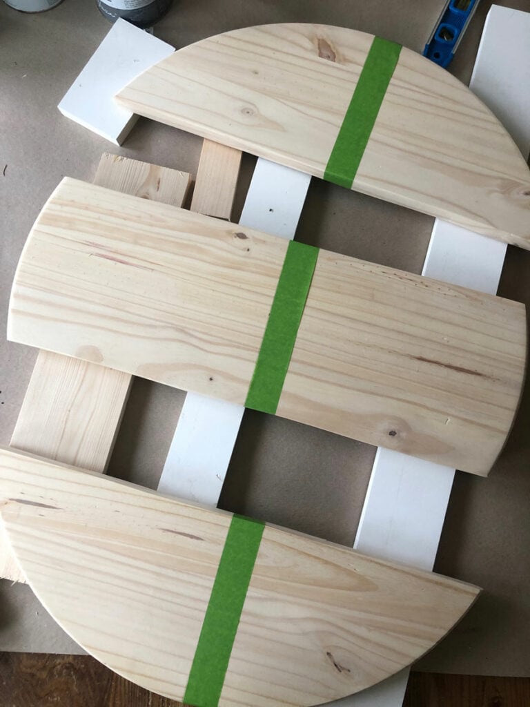 three pieces of wood with green tape