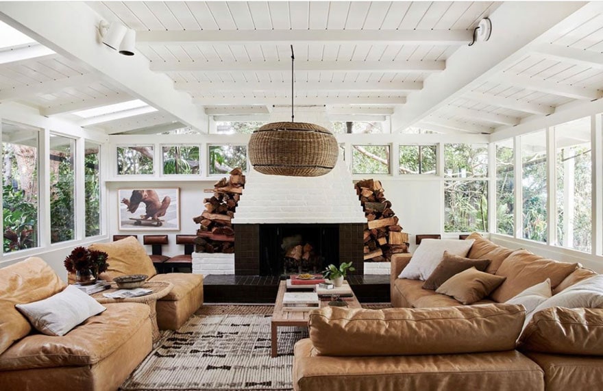 white painted brick feireplaecm leather sofas, pendant light, stacked wood