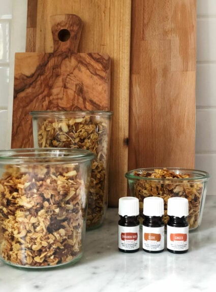 granola in glass jars with small essential oil bottles, wood cutting boards