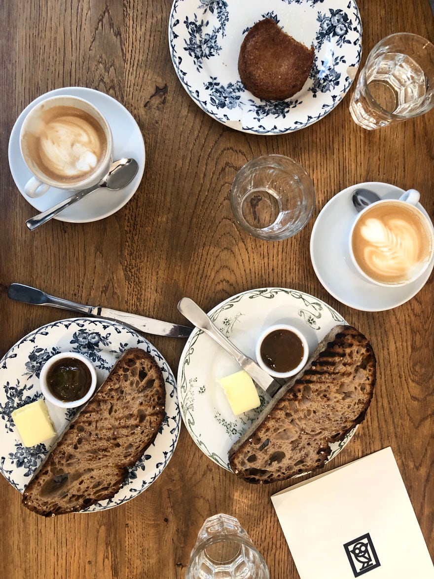coffee, plates with bread and butter, glasses, knives