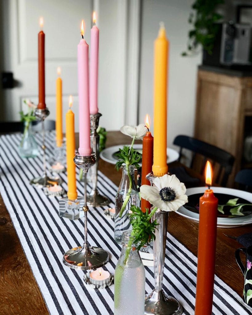 differnt color candles on table with black and white runner