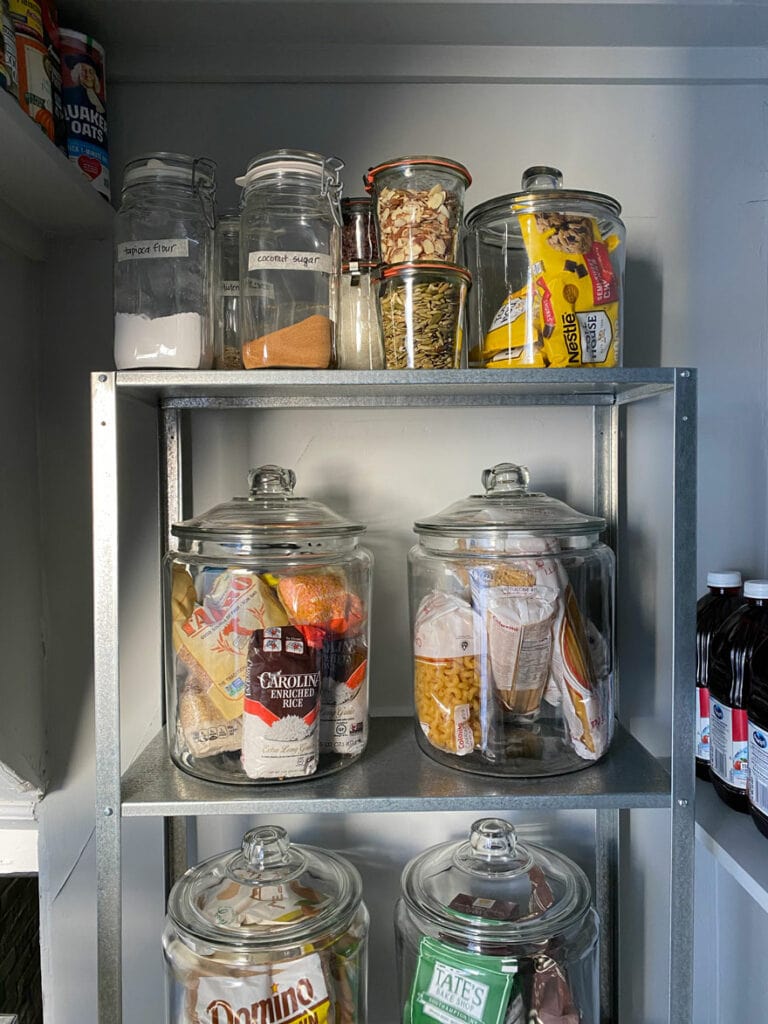glass jars on metal shelves in a pantry space