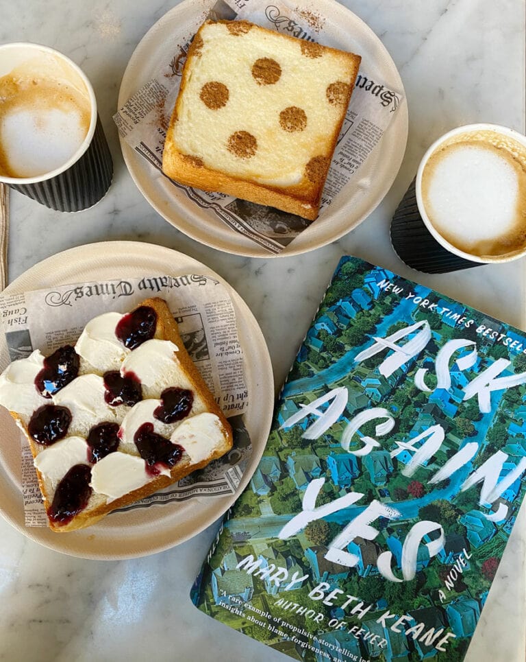 copy of book, Ask Again, Yes and coffee cups and toast on plates on marble table top