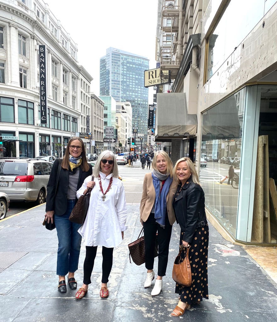 4 women on sidewalk in urban setting