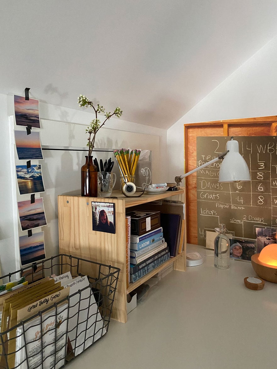 desk with photos, lamp, basket, bottle with flowers