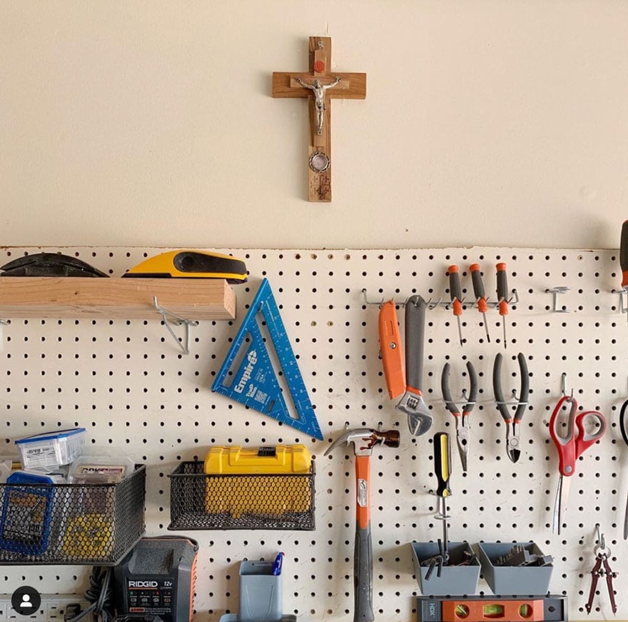 a workshop with a peg board and tool, plus a cross