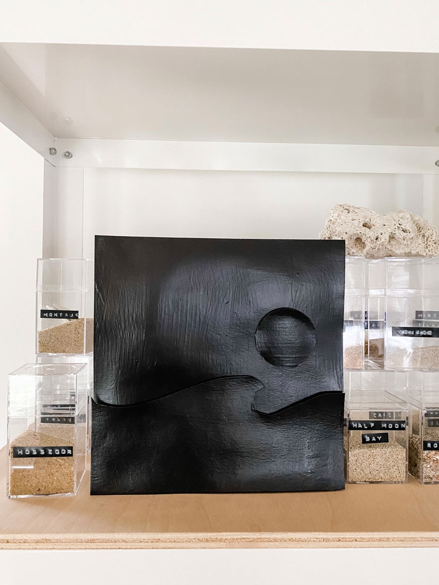 black painted collage with boxes of sand