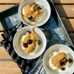 3 white bowls on galvanized tray with ice-cream and dalogona whipped coffee with choc late covered espresso beans