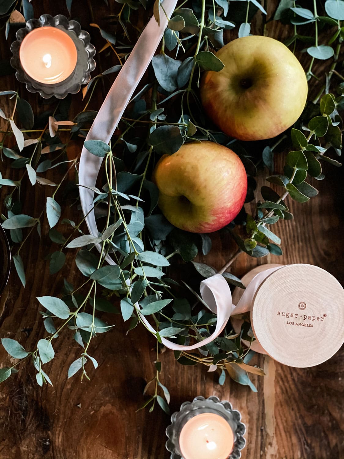 apples, eucalyptus and ribbon on farm table