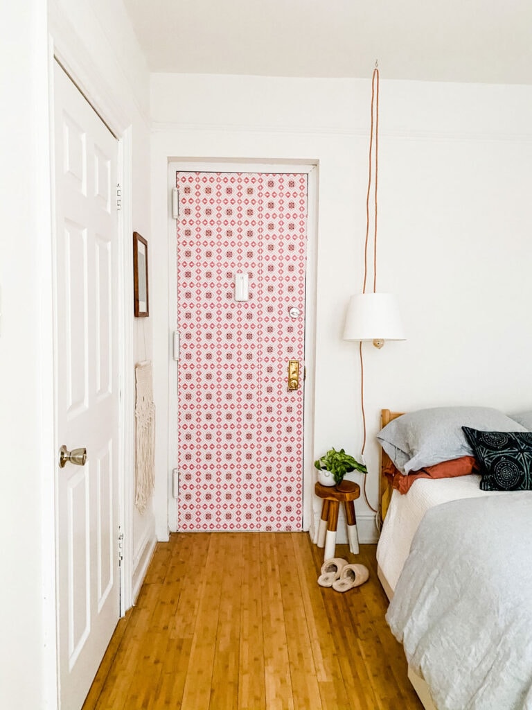 wallpaper on door, pendant lamp, stool, plant