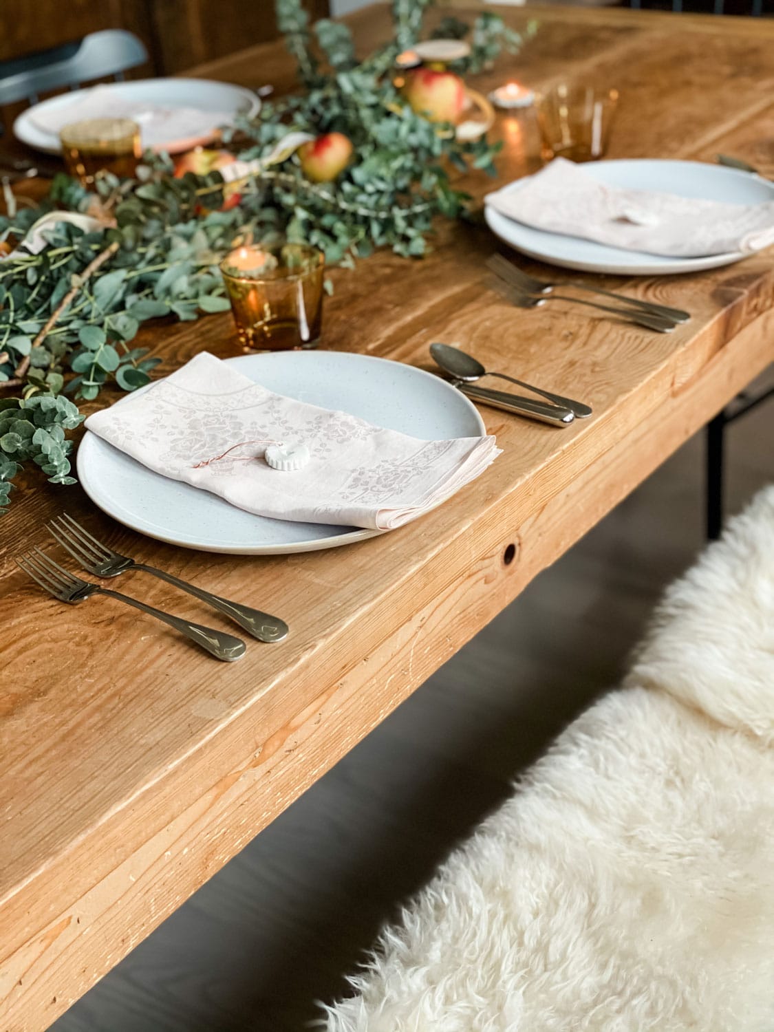 bench with sheepskins at a table set for thanksgiving 
