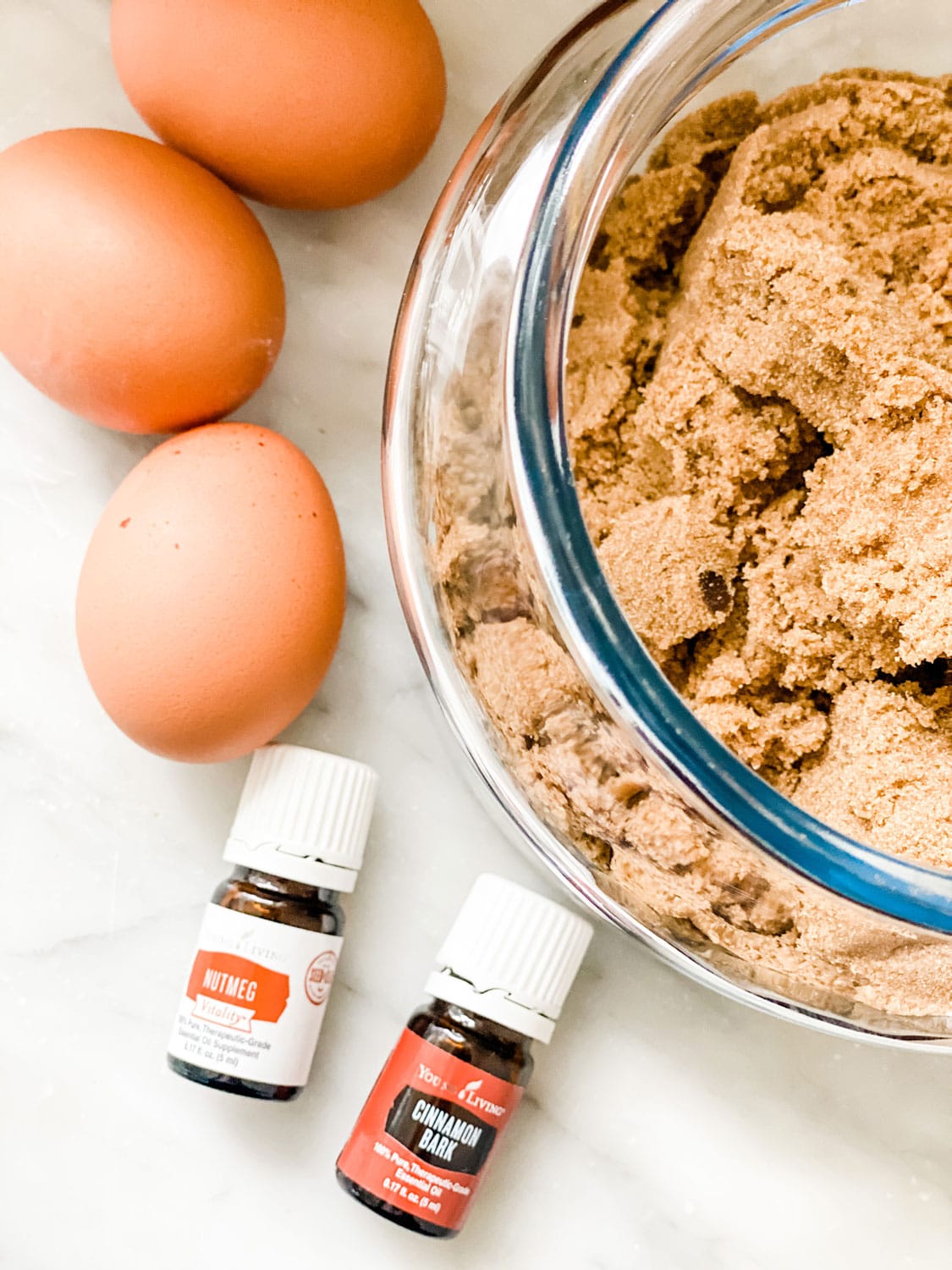 eggs, brown sugar in bowl, vitality oils on marble counter