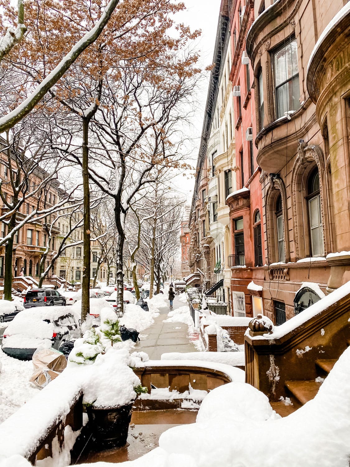 city street in the snow with brownstones