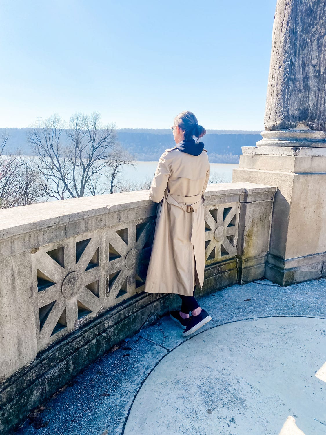 long length burberry coat on woman wearing black overlooking The Hudson River