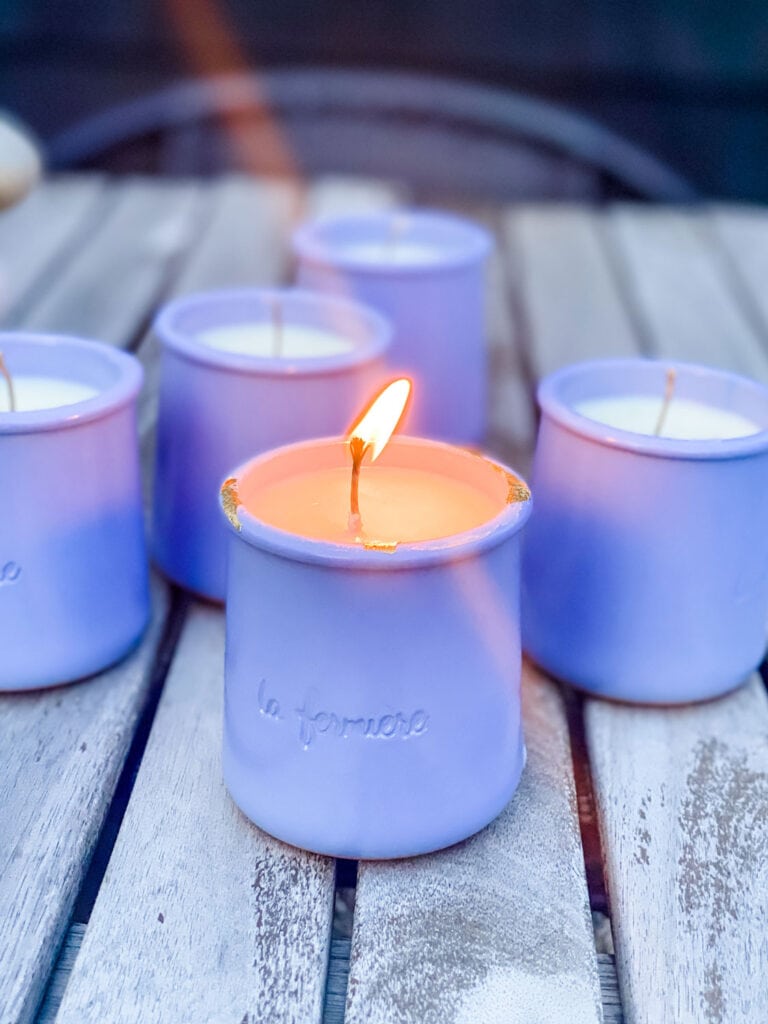 candles in periwinkle yogurt pots on wood table