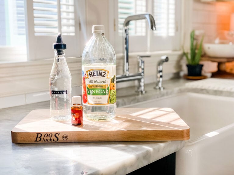 wood cutting board, vinegar, clear bottle and tea tree