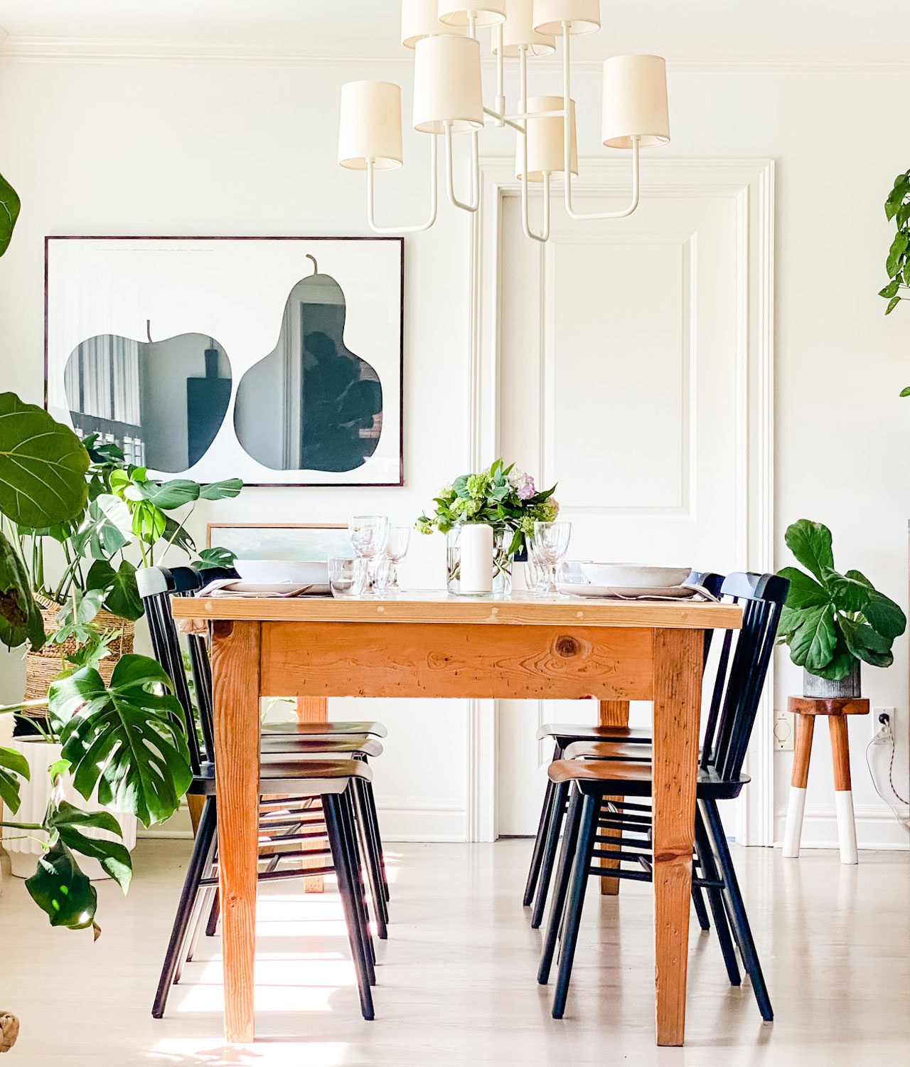 farm table with black chairs, plants, Enzo Mari apple pear poster