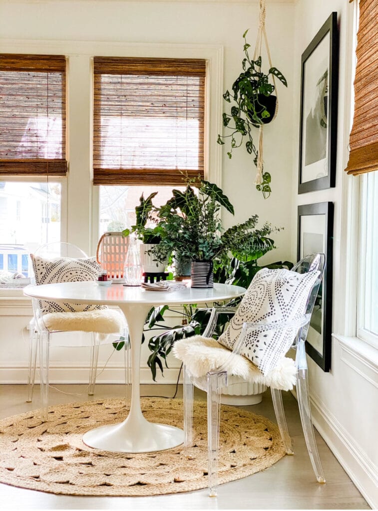 A corner of a living room with a round Saarinen table and some chairs.