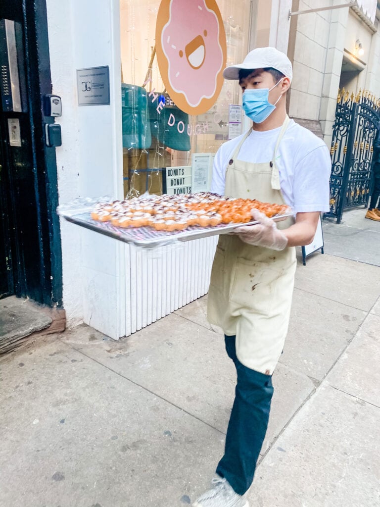A cook is bringing in fresh donuts to sell at Taiyaki in the Chinatown neighborhood of Manattan.