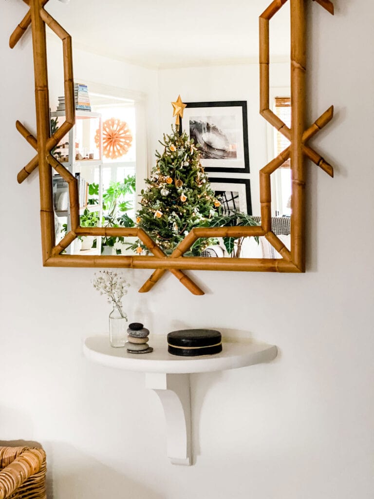 A few stacked stones from the beach, a clear glass bottle with a sprig of baby’s breath, and a ceramic box sit on a small, custom-build shelf in the entryway.