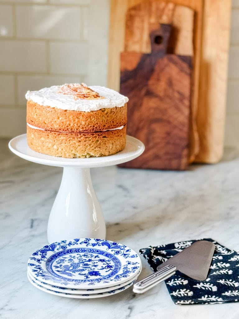 Two six inch round cakes are layered and topped with butter cream and candied orange peels.