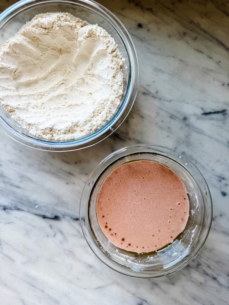 The wet and dry ingredients for making blood orange olive oil cake are mixed in separate bowls and are ready to be combined.