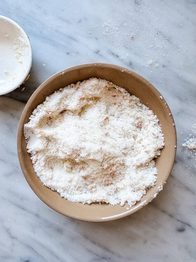 Blood orange zest and sugar are mixed in a small brown bowl.