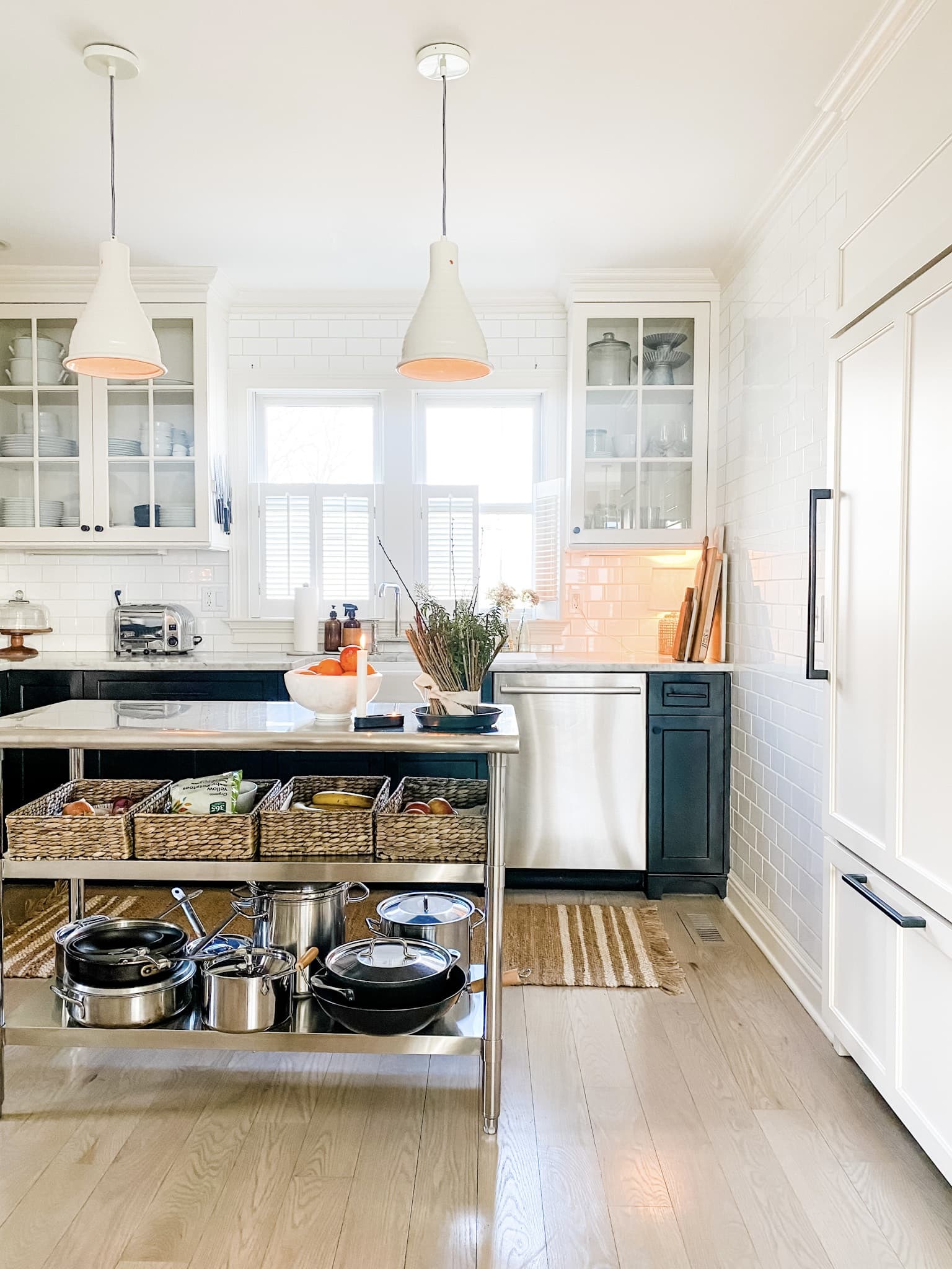 black and white kitchen with oranges in white bowl on island with ceramic pendant lights