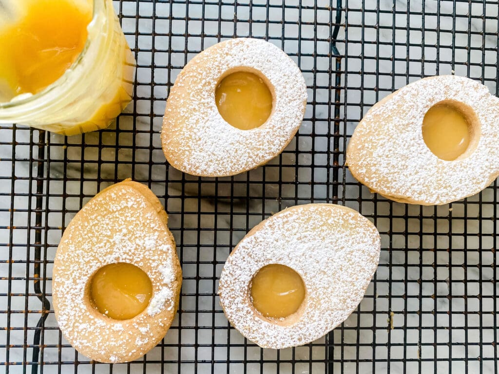 Egg-shaped shortbread cookies with lemon curd filling and lemon curd that resembles an egg yolk.