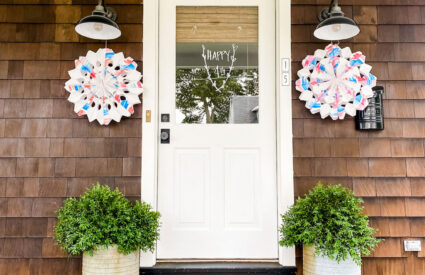 front porch with 2 decorations on each side of door on black barn lights