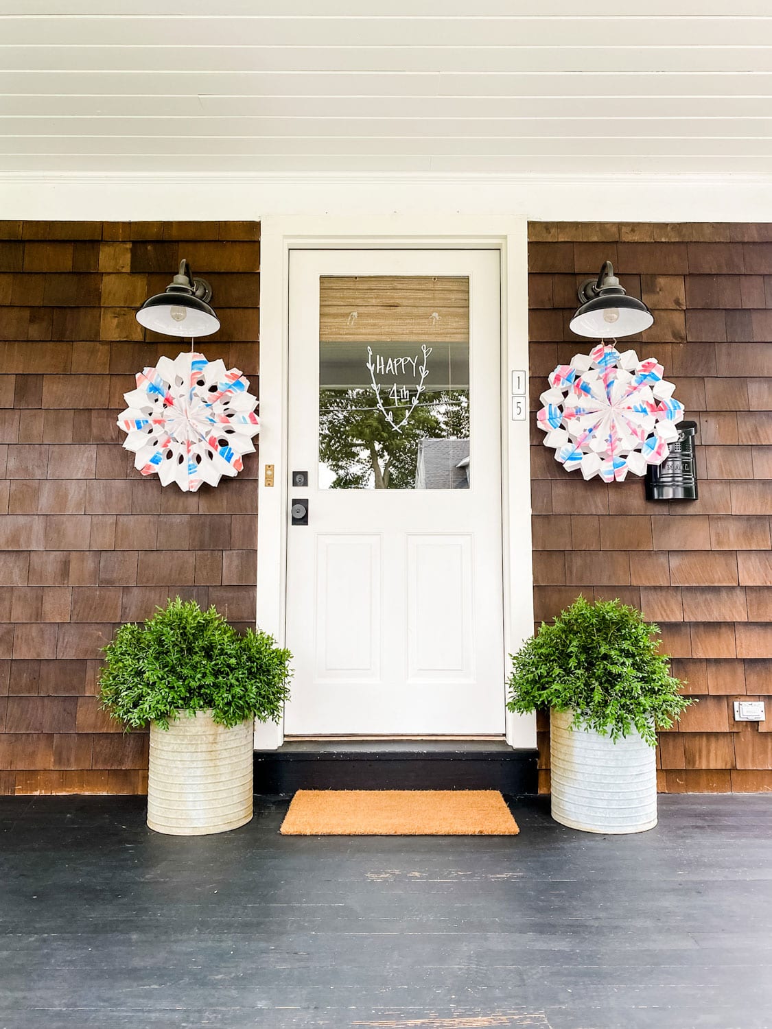 front porch with 2 decorations on each side of door on black barn lights