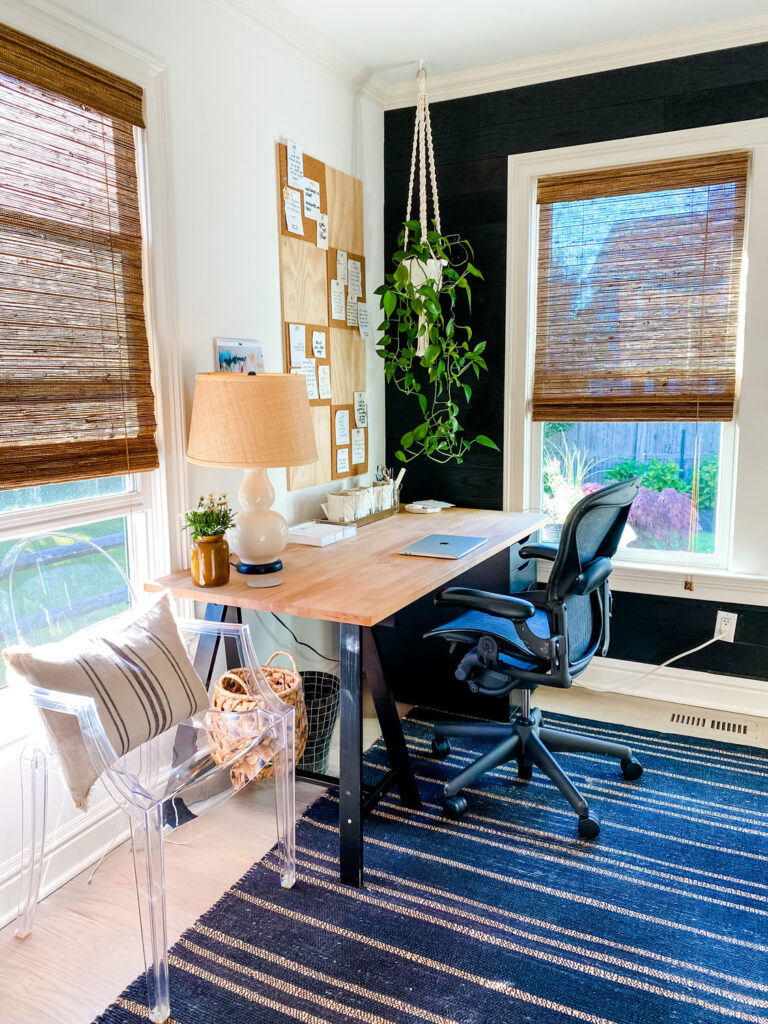 home office with windows, desk, chair, plant.