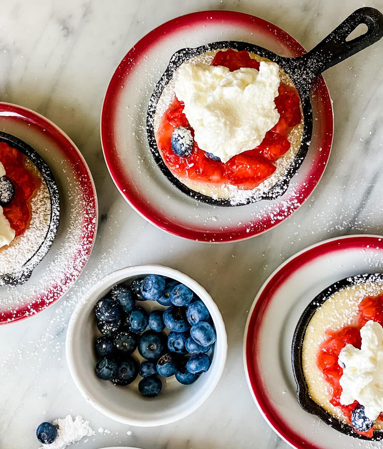 individual cast iron skillets with strawberry shortcakes with whipped topping