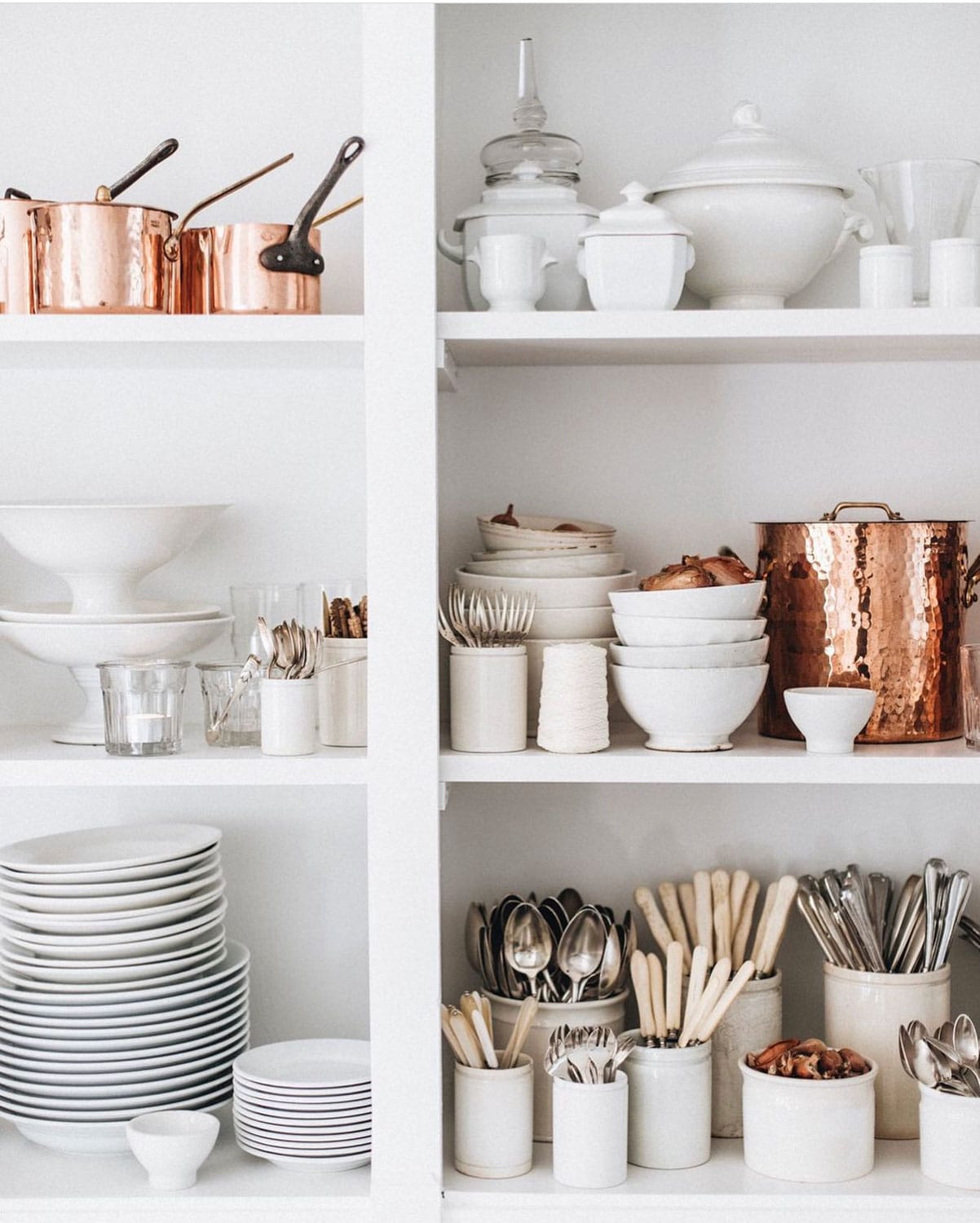 Copper pots, stacked of Apilco dishes, cups of silverware